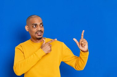 Mavi arka planda sarı formalı Afrikalı adam.