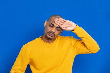 Mavi arka planda sarı formalı Afrikalı adam.