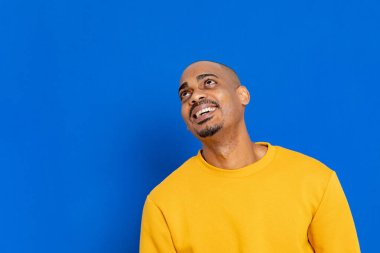 Mavi arka planda sarı formalı Afrikalı adam.