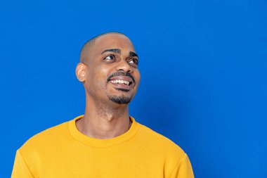 Mavi arka planda sarı formalı Afrikalı adam.