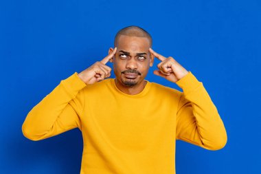 Mavi arka planda sarı formalı Afrikalı adam.