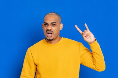 Mavi arka planda sarı formalı Afrikalı adam.