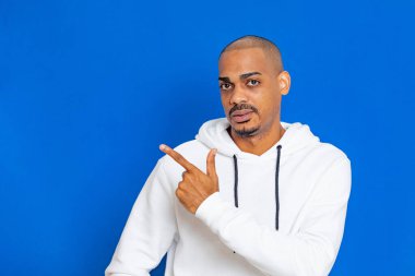 Mavi arka planda beyaz bir kazak giyen Afrikalı adam.