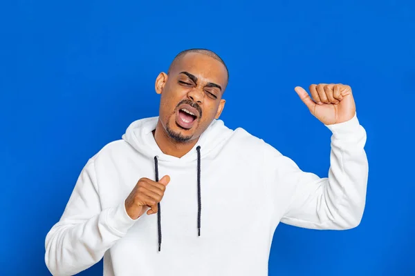 Chico Africano Con Una Sudadera Blanca Sobre Fondo Azul —  Fotos de Stock