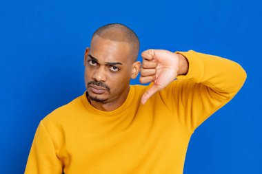 Mavi arka planda sarı formalı Afrikalı adam.