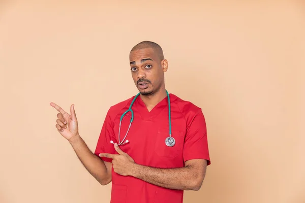 Turuncu Arka Planda Kırmızı Üniforma Giyen Afrikalı Bir Doktor — Stok fotoğraf