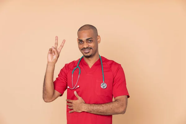 Ganador Médico Africano Con Uniforme Rojo Sobre Fondo Naranja —  Fotos de Stock