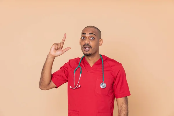 Médico Africano Con Uniforme Rojo Sobre Fondo Naranja —  Fotos de Stock