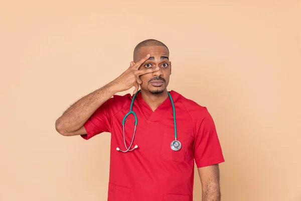 Médico Africano Con Uniforme Rojo Sobre Fondo Naranja —  Fotos de Stock