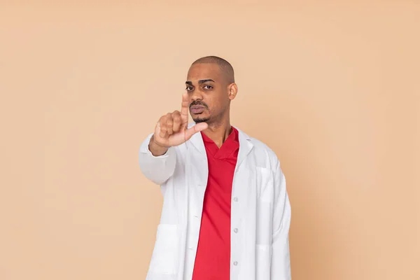 Médico Africano Apuntando Cámara Sobre Fondo Naranja —  Fotos de Stock