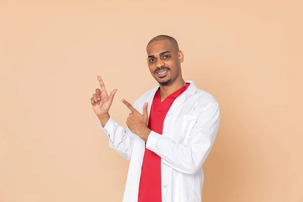 Africký Lékař Indikuje Něco Oranžovém Pozadí — Stock fotografie