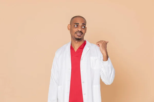 African Doctor Indicating Something Orange Background — Stock Photo, Image