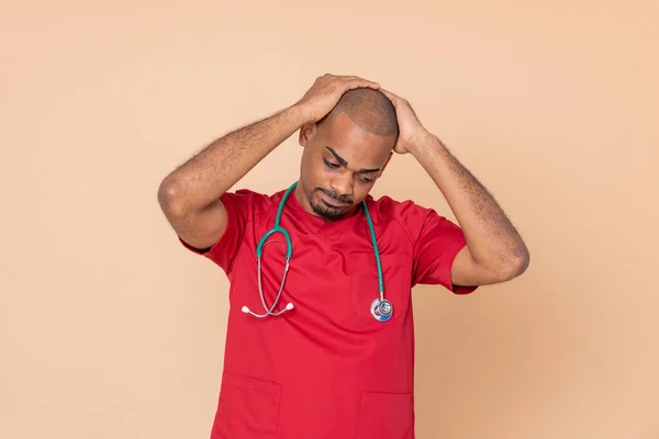 Worried doctor with a red uniform on a yellow background
