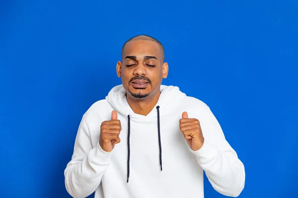 Chico Africano Con Una Sudadera Blanca Sobre Fondo Azul —  Fotos de Stock