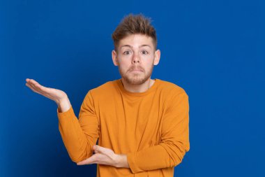 Mavi arka planda sarı tişörtlü çekici bir genç.