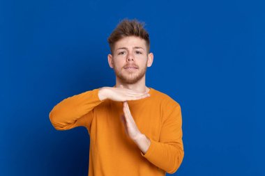 Mavi arka planda sarı tişörtlü çekici bir genç.