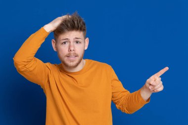 Mavi arka planda sarı tişörtlü çekici bir genç.