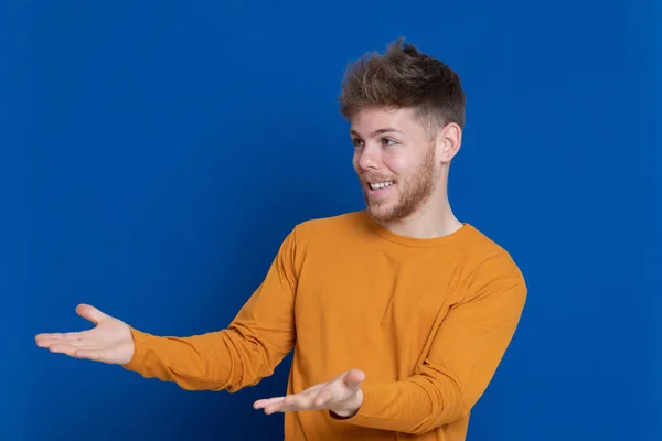 Aantrekkelijke Jongeman Met Een Geel Shirt Een Blauwe Achtergrond — Stockfoto