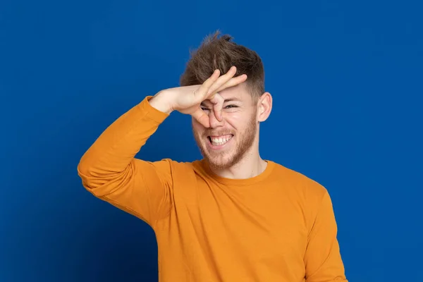 Aantrekkelijke Jongeman Met Een Geel Shirt Een Blauwe Achtergrond — Stockfoto