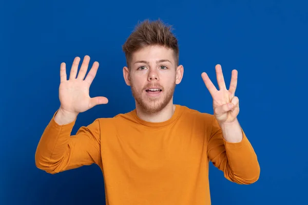 Attraktiver Junger Mann Mit Gelbem Shirt Auf Blauem Hintergrund — Stockfoto