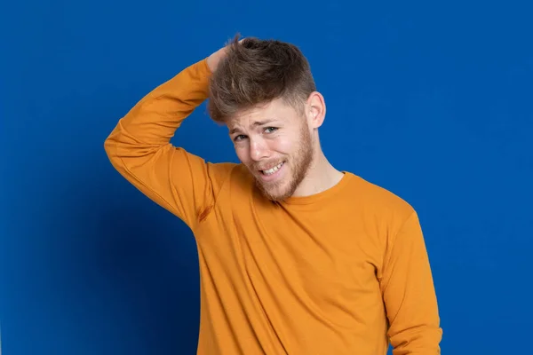 Atraktivní Mladý Muž Žlutým Tričkem Modrém Pozadí — Stock fotografie
