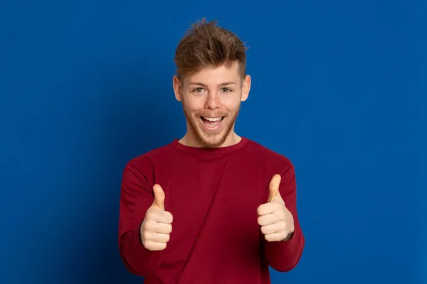 Atractivo Joven Con Una Camiseta Roja Sobre Fondo Azul —  Fotos de Stock