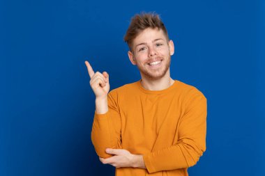 Mavi arka planda sarı tişörtlü çekici bir genç.