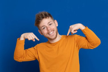 Mavi arka planda sarı tişörtlü çekici bir genç.