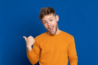 Mavi arka planda sarı tişörtlü çekici bir genç.