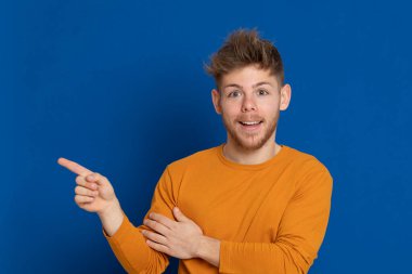 Mavi arka planda sarı tişörtlü çekici bir genç.