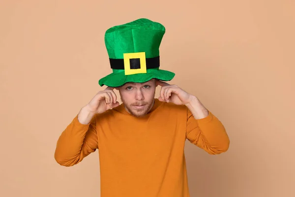 迷人的小伙子 戴着一顶黄色背景的绿色大帽子 — 图库照片
