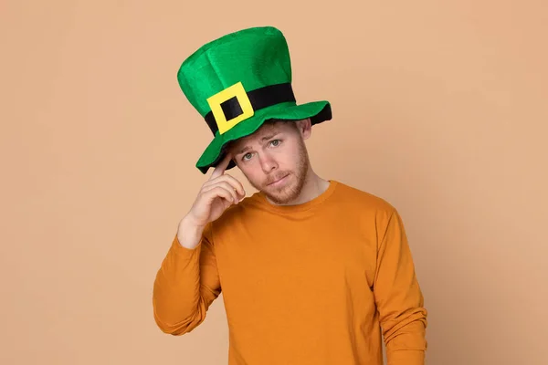 Sarı Arka Planda Büyük Yeşil Şapkalı Çekici Bir Genç — Stok fotoğraf