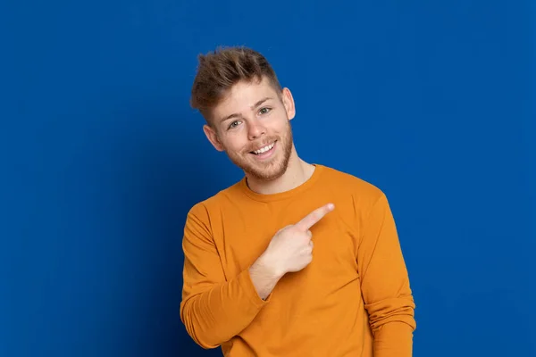 Aantrekkelijke Jongeman Met Een Geel Shirt Een Blauwe Achtergrond — Stockfoto