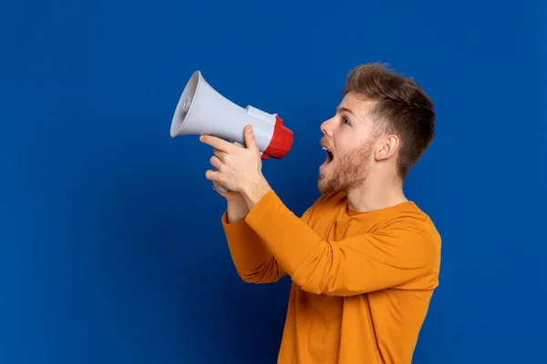 Atraktivní Mladý Muž Žlutým Tričkem Modrém Pozadí — Stock fotografie