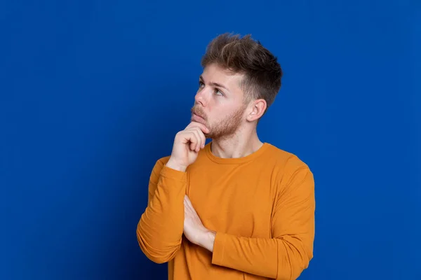 Attraktiver Junger Mann Mit Gelbem Shirt Auf Blauem Hintergrund — Stockfoto