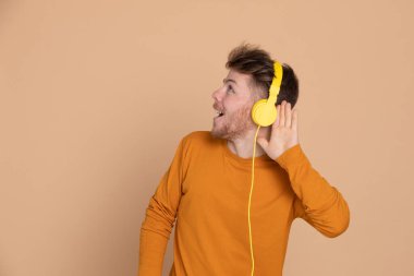 Sarı arka planda çekici bir genç.