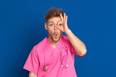 Mavi arka planda pembe üniformalı Afrikalı bir doktor.