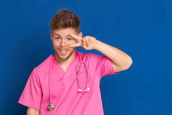 身穿蓝色背景粉红制服的非洲医生 — 图库照片