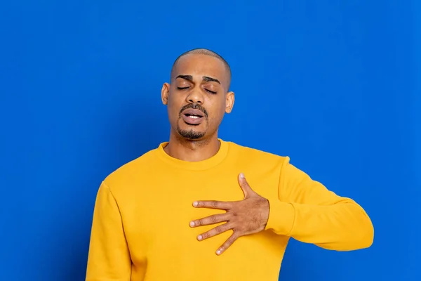 Chico Africano Con Una Camiseta Amarilla Sobre Fondo Azul —  Fotos de Stock