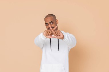 Sarı arka planda beyaz kazaklı Afrikalı bir adam.