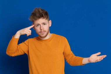 Mavi arka planda sarı tişörtlü çekici bir genç.