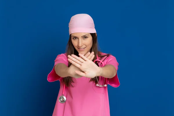 Médico Joven Con Uniforme Rosa Sobre Fondo Azul — Foto de Stock