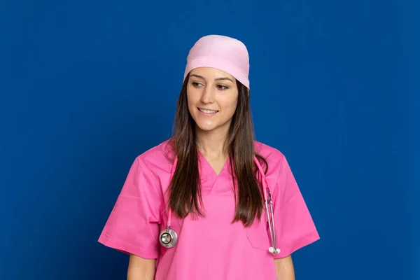 若いです医師とともにピンクの制服で青の背景 — ストック写真