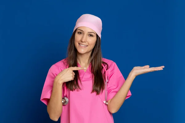 Médico Joven Con Uniforme Rosa Sobre Fondo Azul — Foto de Stock