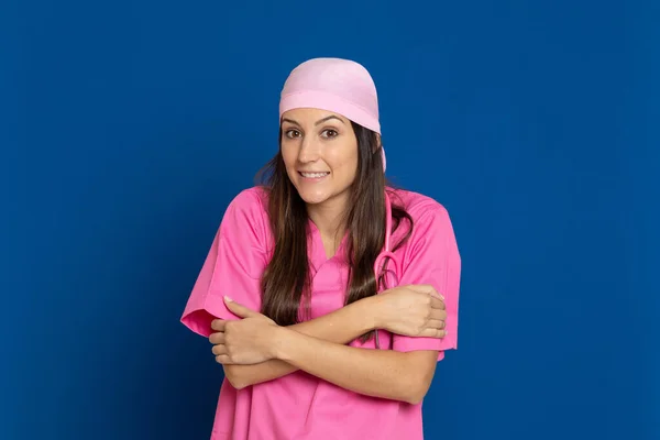 Médico Joven Con Uniforme Rosa Sobre Fondo Azul —  Fotos de Stock