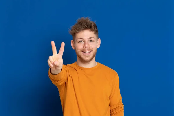 Jovem Atraente Com Uma Camiseta Amarela Fundo Azul — Fotografia de Stock