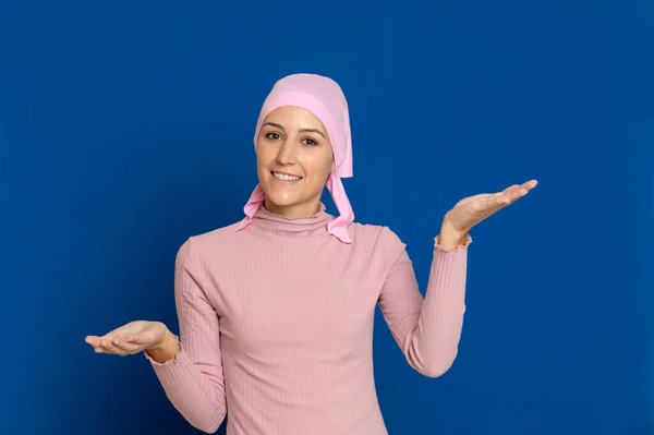 Young woman with pink scarf on the head on a blue background