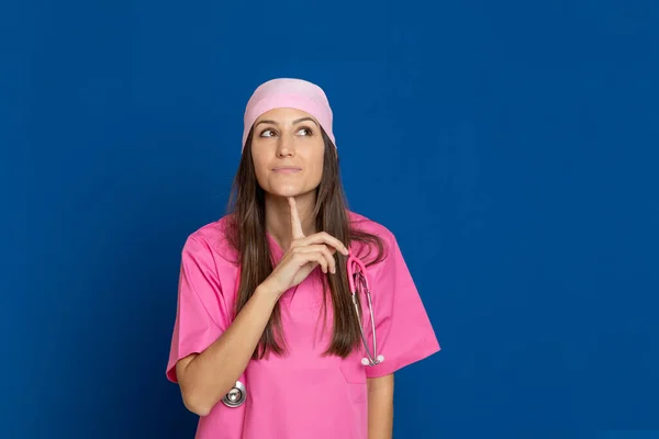 Médico Joven Con Uniforme Rosa Sobre Fondo Azul — Foto de Stock