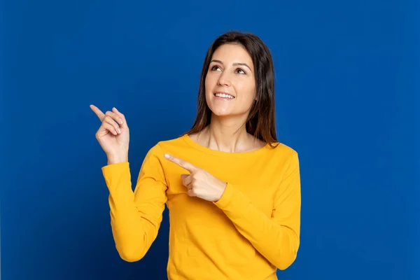 Chica Morena Con Una Camiseta Amarilla Sobre Fondo Azul —  Fotos de Stock