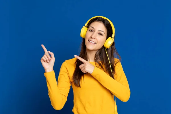 Brunette girl wearing a yellow T-shirt on a blue background